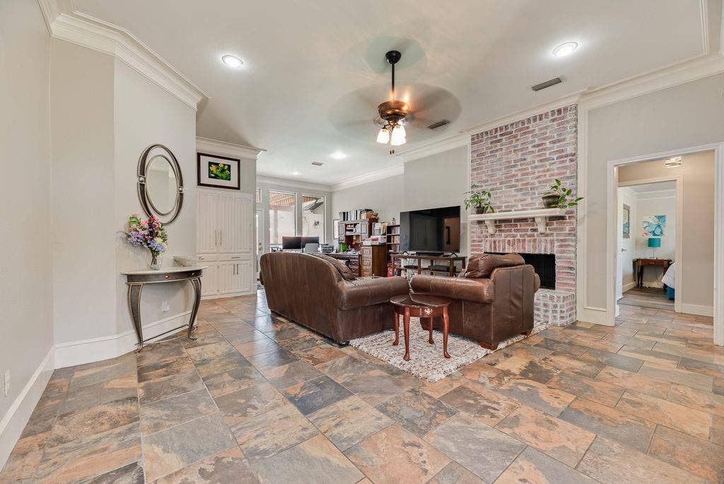 419 N Winding Oaks Drive, Wylie, TX 75098 Spacious living area featuring multi-tone tile flooring, a painted brick fireplace with hearth and mantel, and built-in cabinetry