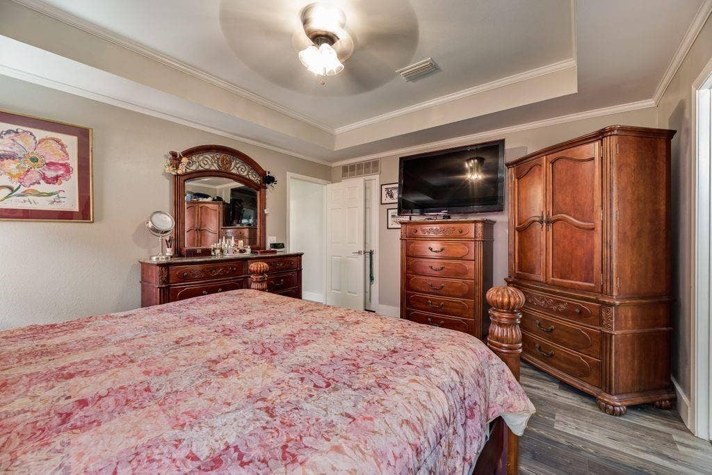 419 N Winding Oaks Drive, Wylie, TX 75098 Tray ceiling with crown molding, wood-finish flooring, and a ceiling fan with light fixture