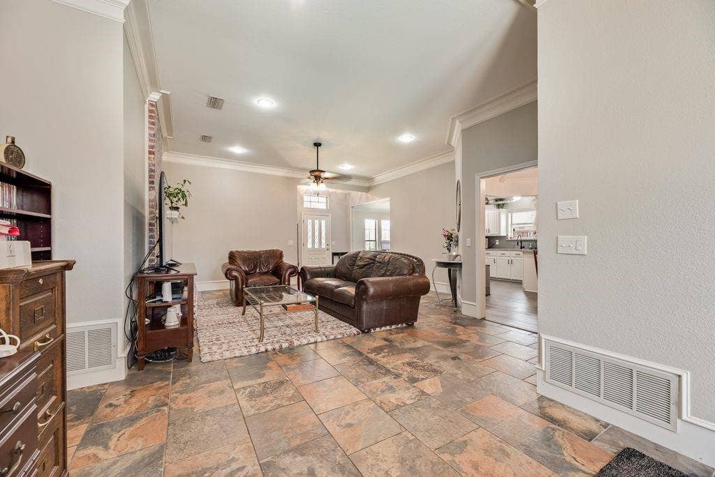 419 N Winding Oaks Drive, Wylie, TX 75098 Living area featuring large format stone tile flooring, crown molding, recessed lighting, and a ceiling fan
