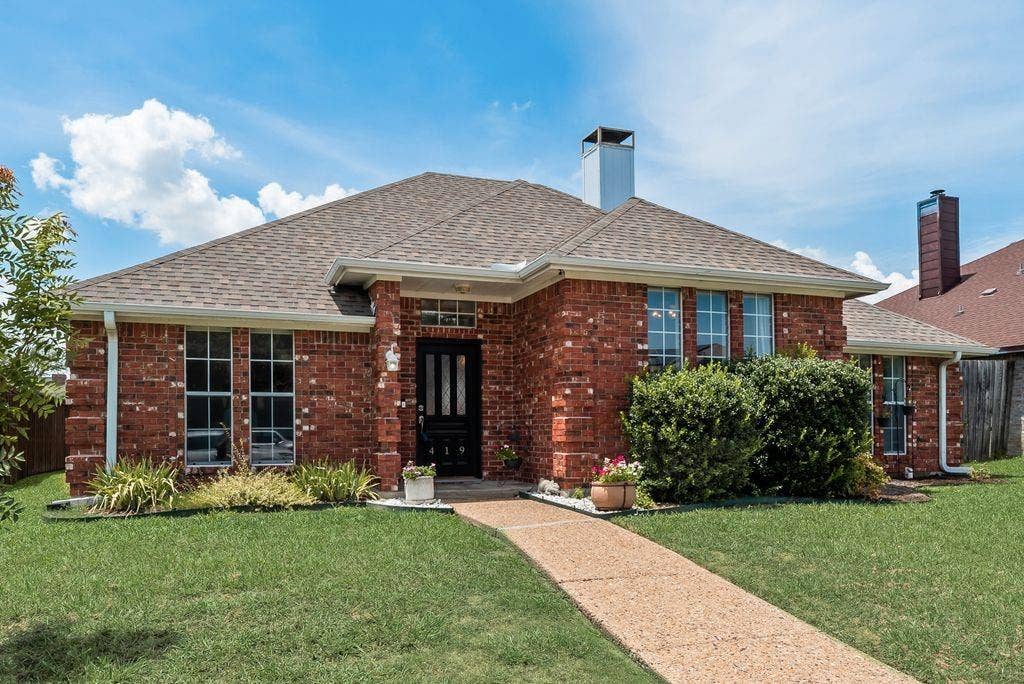 419 N Winding Oaks Drive, Wylie, TX 75098 Red brick exterior featuring a brown shingle roof and white gutters