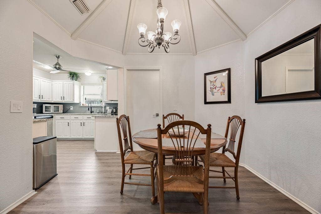 419 N Winding Oaks Drive, Wylie, TX 75098 Open-concept dining area featuring a vaulted ceiling with exposed beams, central chandelier, and wood-finish flooring