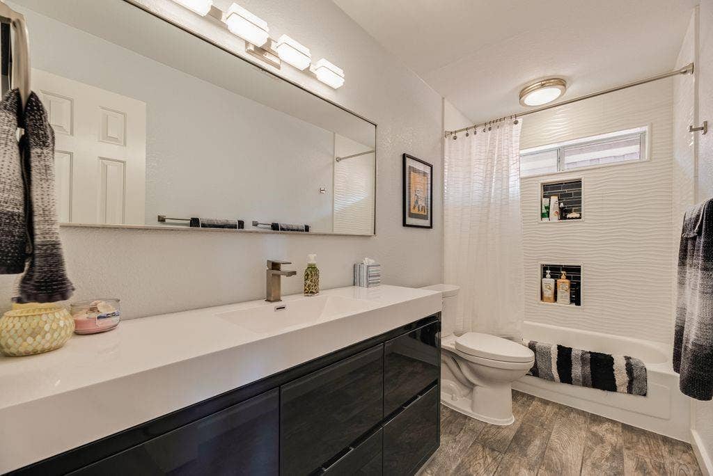 419 N Winding Oaks Drive, Wylie, TX 75098 Bathroom featuring a wide vanity with dark cabinetry, an integrated sink, and wood-finish flooring