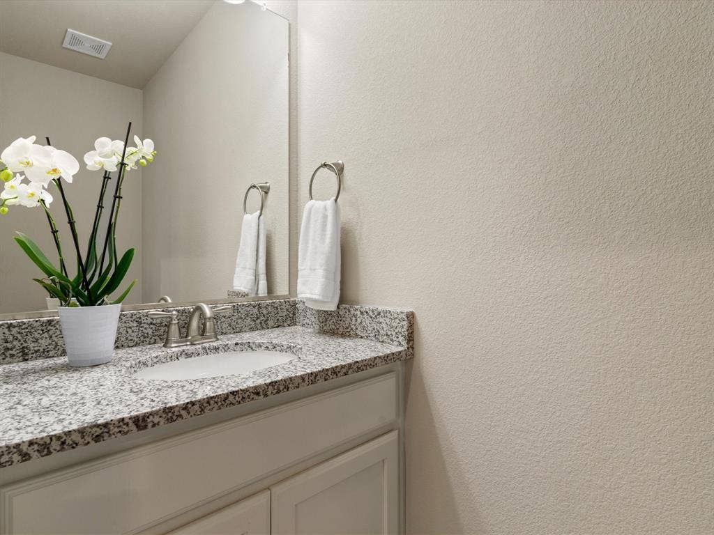 2703 Navarro Trail, Euless, TX 76039 Vanity with a granite countertop, an undermount sink, and a brushed nickel faucet