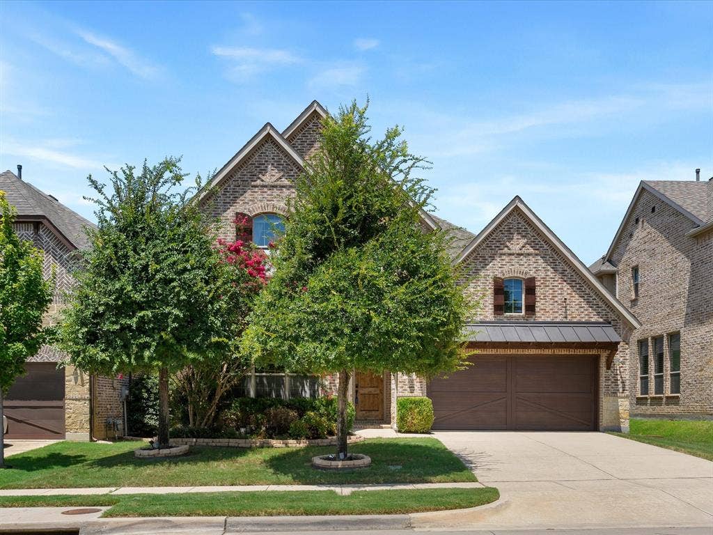 2703 Navarro Trail, Euless, TX 76039 Brick facade residence featuring multiple gables, an arched window, and a concrete driveway