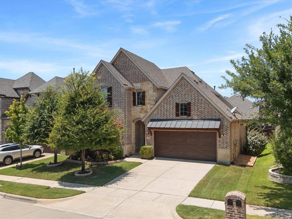 2703 Navarro Trail, Euless, TX 76039 Brick and stone facade residence featuring a two-car garage with an awning