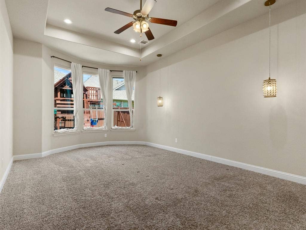 2703 Navarro Trail, Euless, TX 76039 Tray ceiling with recessed lighting/decorative lighting and bay window with a ceiling fan