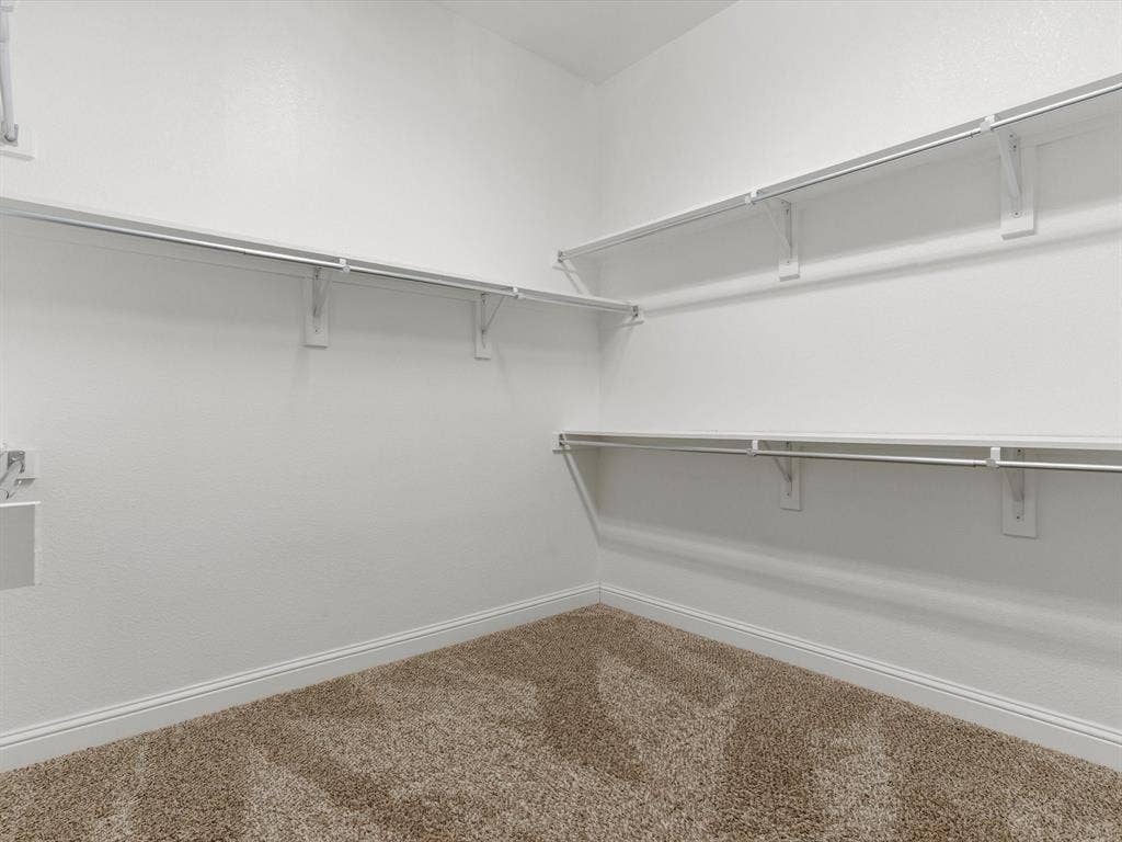 2703 Navarro Trail, Euless, TX 76039 Open closet space featuring wall-mounted wire shelving and hanging rods