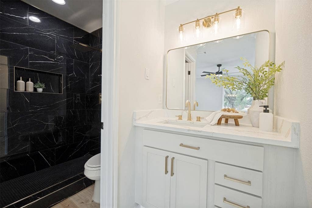 641 Stroud Lane, Garland, TX 75043 White vanity with gold-tone hardware, rectangular mirror, and a gold-tone light fixture