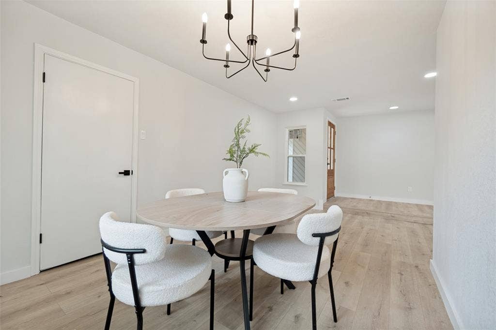 641 Stroud Lane, Garland, TX 75043 Bright interior space with light wood-finish flooring, recessed lighting, and a modern black chandelier