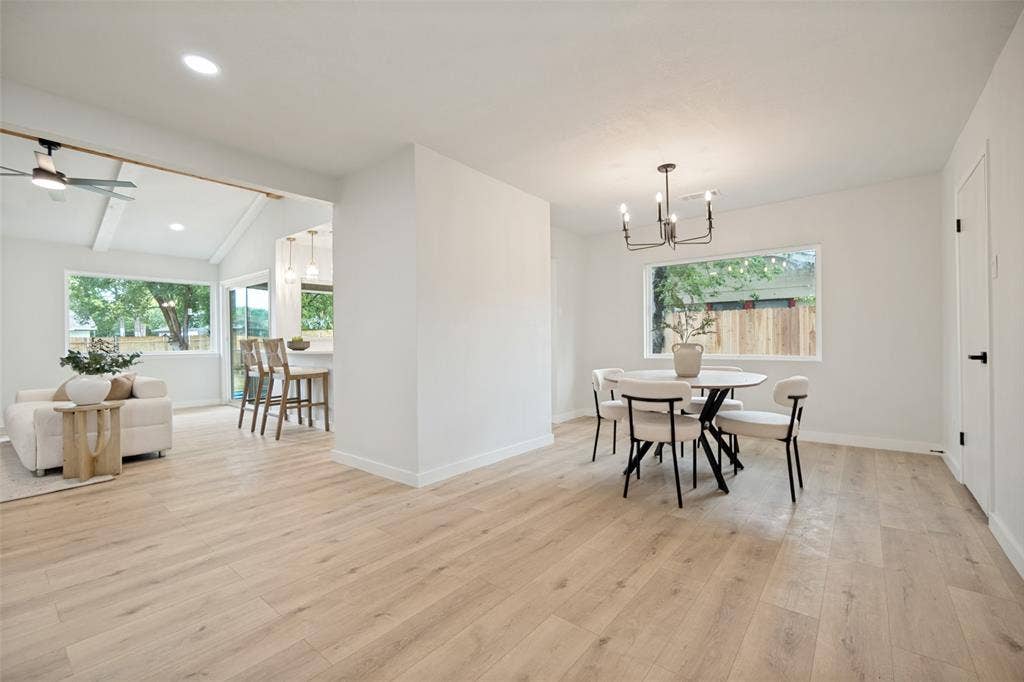 641 Stroud Lane, Garland, TX 75043 Open-concept living space featuring light wood-finish flooring, white walls, and a modern chandelier
