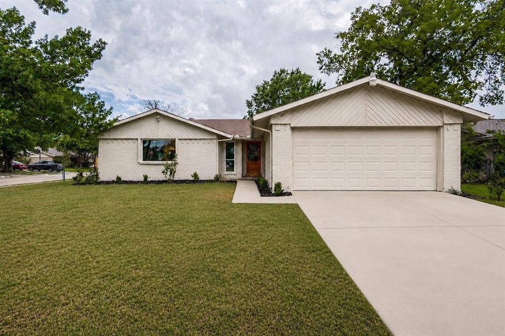 641 Stroud Lane, Garland, TX 75043 Single-story residence featuring light-colored brick and siding, a two-car garage, and a concrete driveway