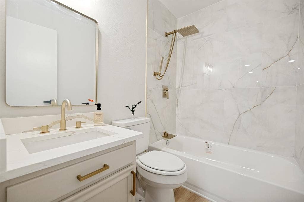 641 Stroud Lane, Garland, TX 75043 Bathroom featuring a white vanity with a rectangular basin sink and gold-tone fixtures