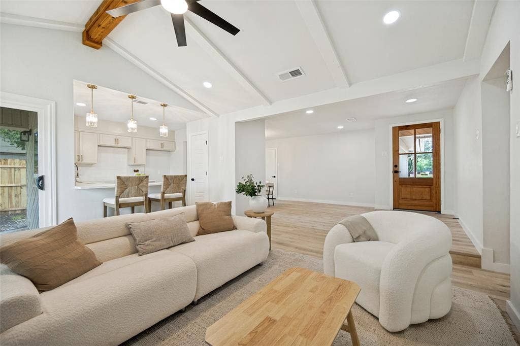 641 Stroud Lane, Garland, TX 75043 Vaulted ceiling living area with a visible kitchen passthrough, wood-finish flooring, recessed lighting, and a prominent wood-panel front door with glass inserts
