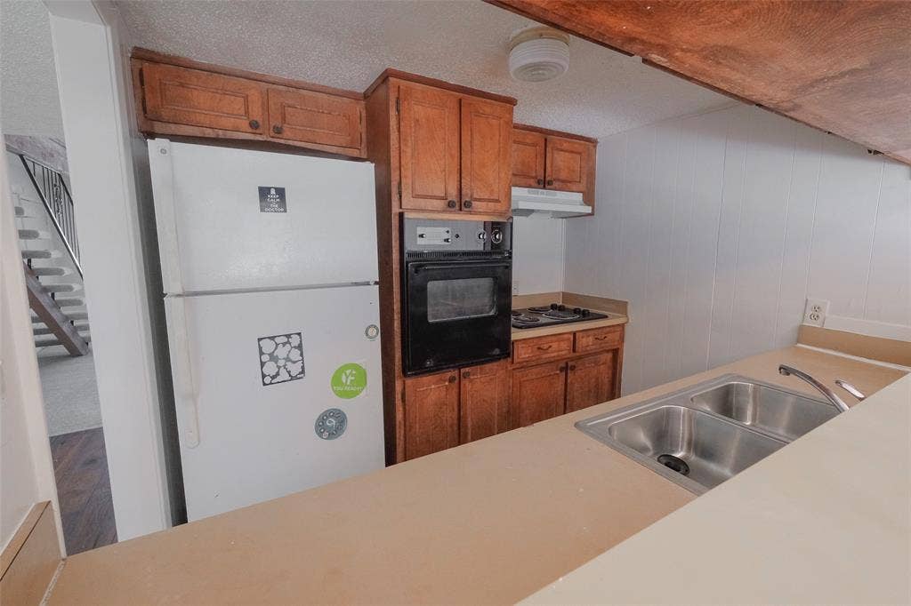 6317 Granbury Road, #6321, Fort Worth, TX 76133 Kitchen featuring a double basin stainless steel sink, built-in oven, gas cooktop, and wood cabinetry