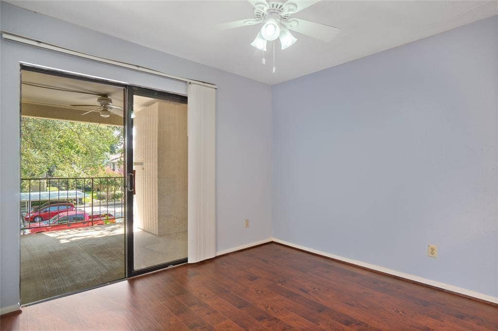 8100 Cambridge Street, #124, Houston, TX 77054 Spacious room with wood-finish flooring, a ceiling fan with integrated lighting, and light blue walls