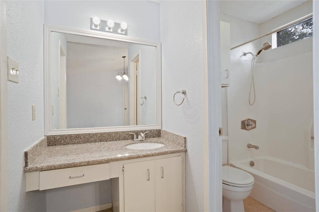 8100 Cambridge Street, #124, Houston, TX 77054 Bathroom featuring a vanity with a light-toned granite countertop, under-mount sink, and framed mirror