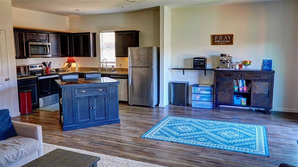 741 Windsor Court, Lavon, TX 75166 Open-concept kitchen with dark wood-finish cabinetry, stainless steel appliances, and wood-finish flooring