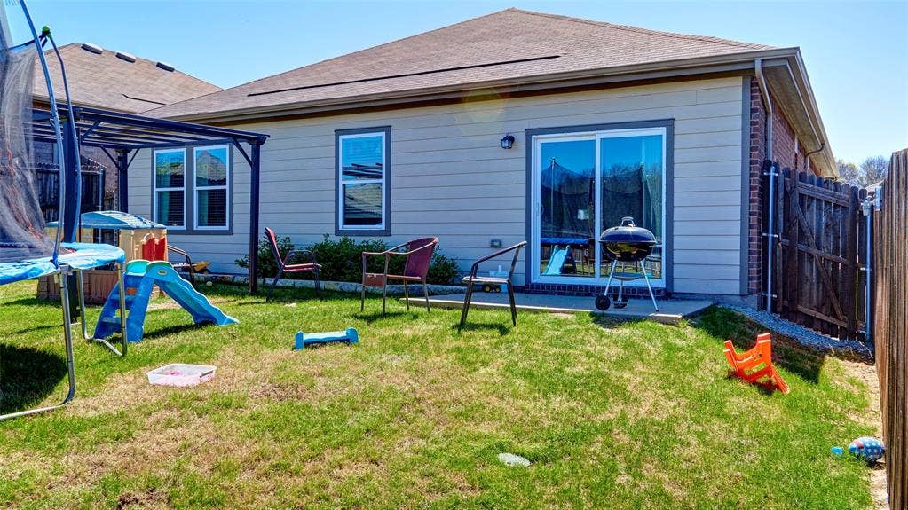 741 Windsor Court, Lavon, TX 75166 Private backyard with a sliding glass door, multiple windows, and a wood privacy fence