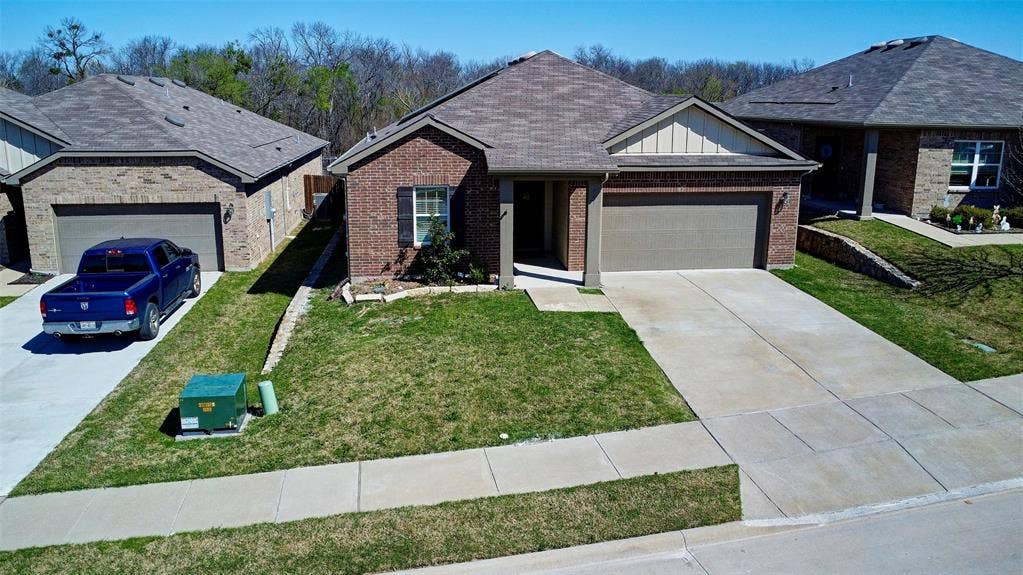 741 Windsor Court, Lavon, TX 75166 Brick facade with an attached two-car garage, concrete driveway, and a front walkway
