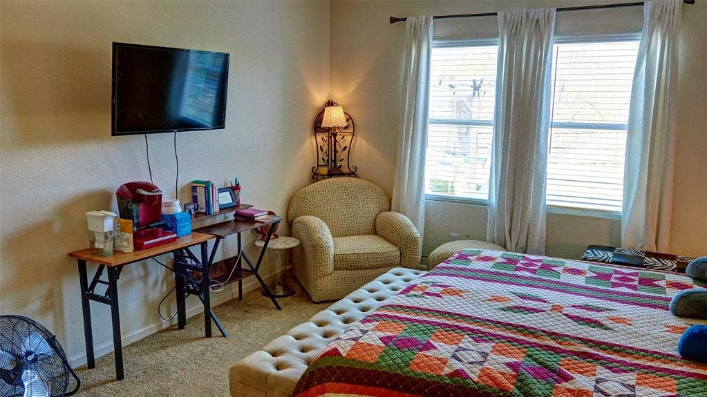 741 Windsor Court, Lavon, TX 75166 Wall-mounted television with visible wiring, carpeted flooring, corner accent lighting, and three tall windows with blinds