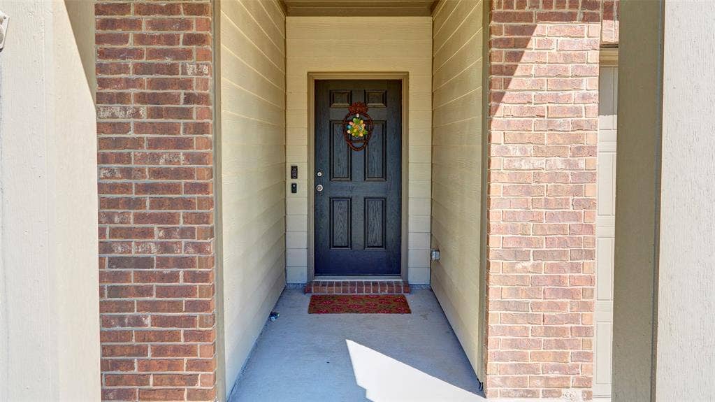 741 Windsor Court, Lavon, TX 75166 Brick and siding exterior facade with a dark paneled entry door and concrete porch