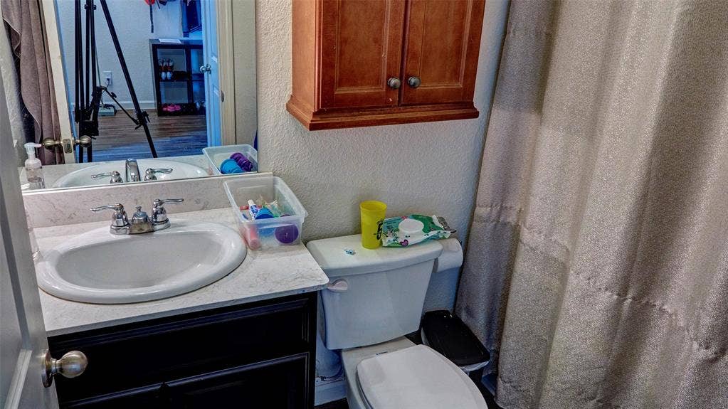 741 Windsor Court, Lavon, TX 75166 White vanity with a single basin, chrome fixtures, and dark cabinetry