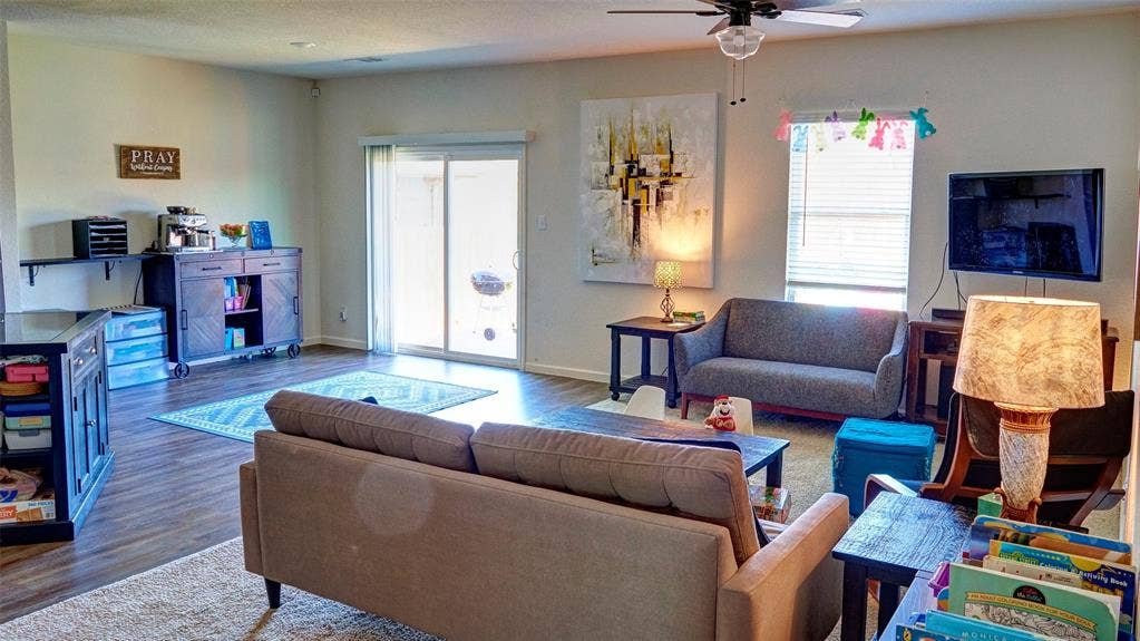 741 Windsor Court, Lavon, TX 75166 Wood-finish flooring, ceiling fan, white walls, and a sliding glass door to the exterior