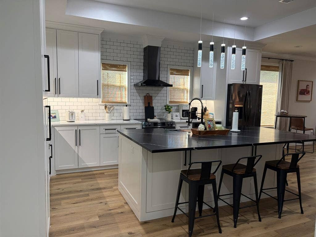 600 Lucas Drive, Athens, TX 75751 Kitchen featuring a central island with countertop seating, white shaker cabinetry, white subway tile backsplash, dark countertops, and wood-finish flooring