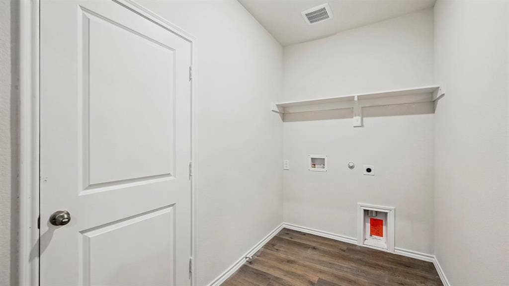 5602 Gannet Place, Crandall, TX 75114 Dedicated laundry area featuring wood-finish flooring, white walls, and a built-in storage shelf