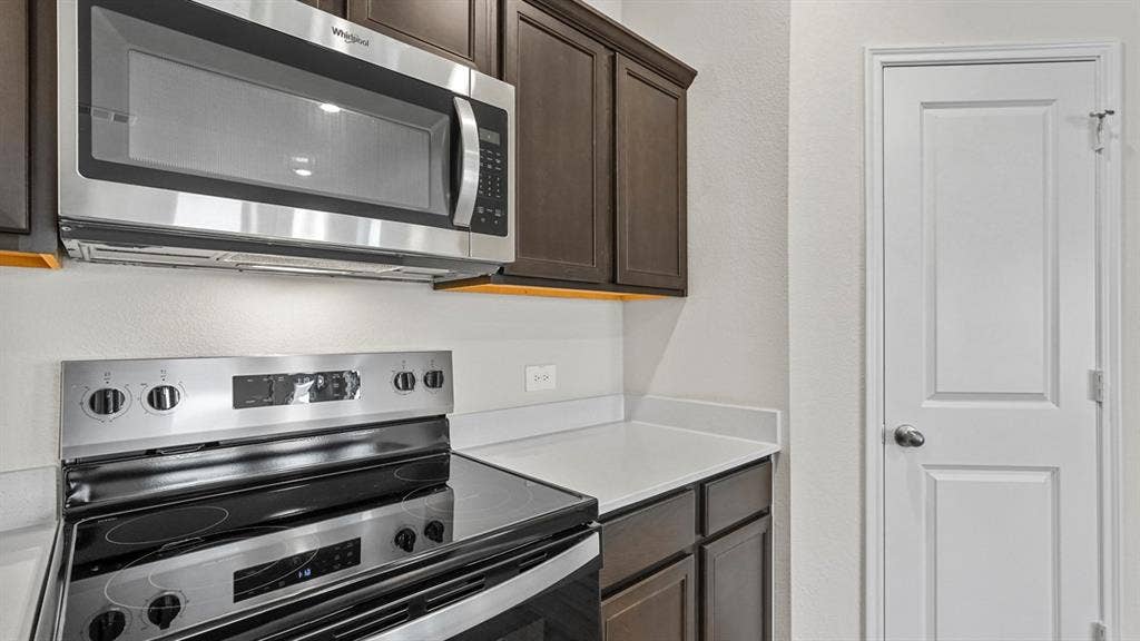 2912 Peppergrass Street, Royse City, TX 75189 Kitchen featuring stainless steel appliances, dark wood cabinetry, white countertops, and under-cabinet lighting