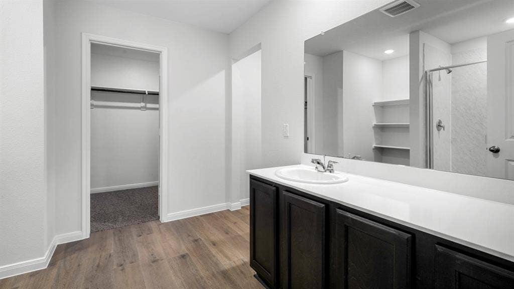 151 Arion Road, Waxahachie, TX 75165 Bathroom vanity featuring a single basin sink, white countertop, and dark wood-finish cabinetry