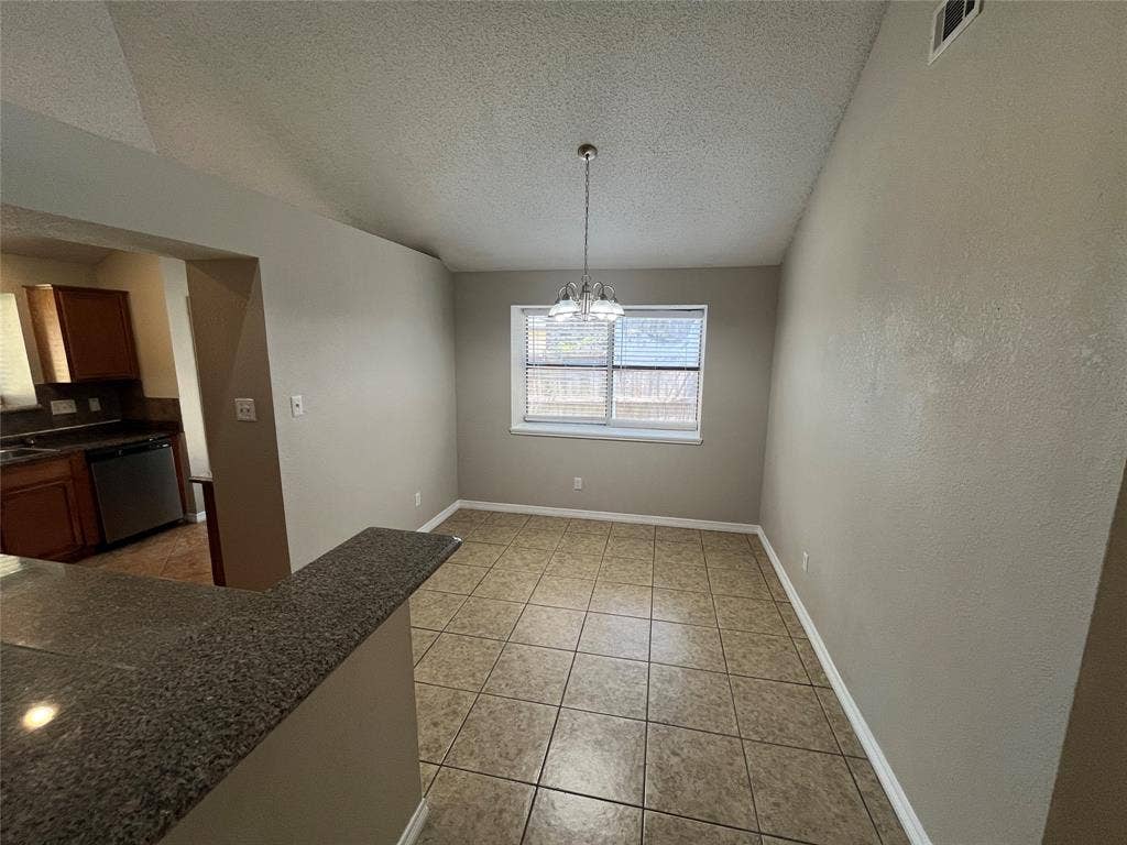2405 Brookside Drive, Rowlett, TX 75088 Tile flooring with a neutral finish, a single window with blinds, and a built-in breakfast bar with a granite-finish countertop