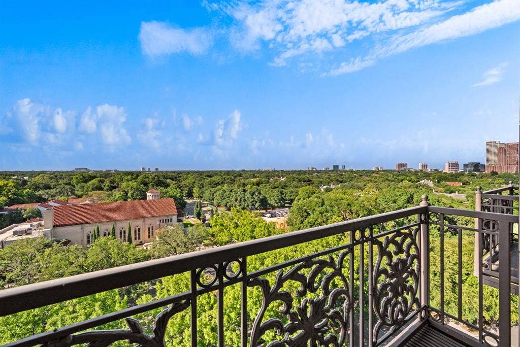 4240 Prescott Avenue, #8B, Dallas, TX 75219 Balcony with ornate wrought iron railing overlooking a tree-lined urban landscape