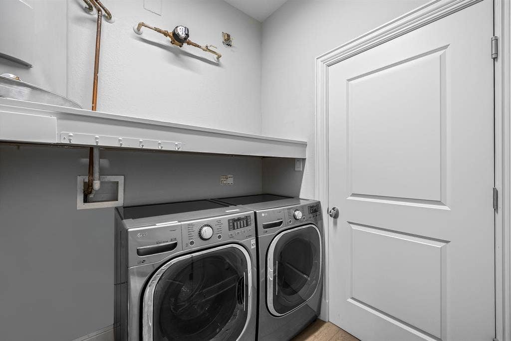 4240 Prescott Avenue, #8B, Dallas, TX 75219 Utility room featuring a paneled door, built-in shelving, and a hanging rack