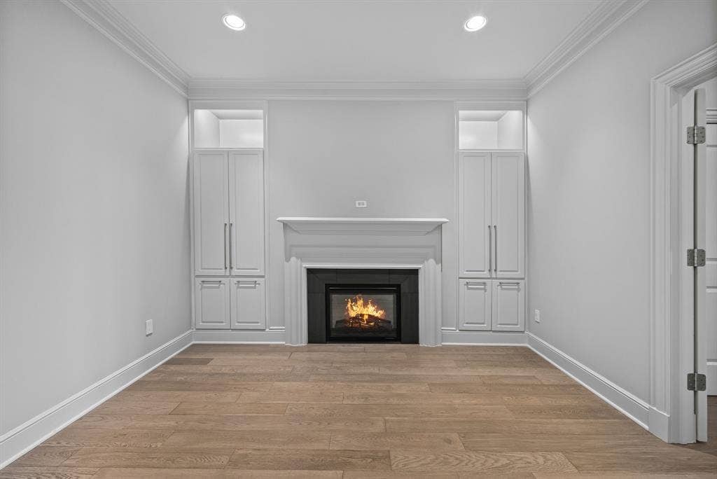4240 Prescott Avenue, #8B, Dallas, TX 75219 Centrally located fireplace with a white mantel, flanked by built-in cabinetry with integrated shelving and recessed lighting