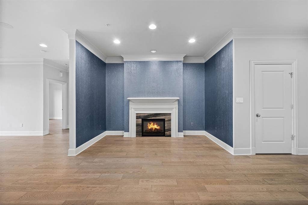 4240 Prescott Avenue, #8B, Dallas, TX 75219 Hardwood-style flooring throughout this room, featuring a fireplace with a white mantel and stone surround