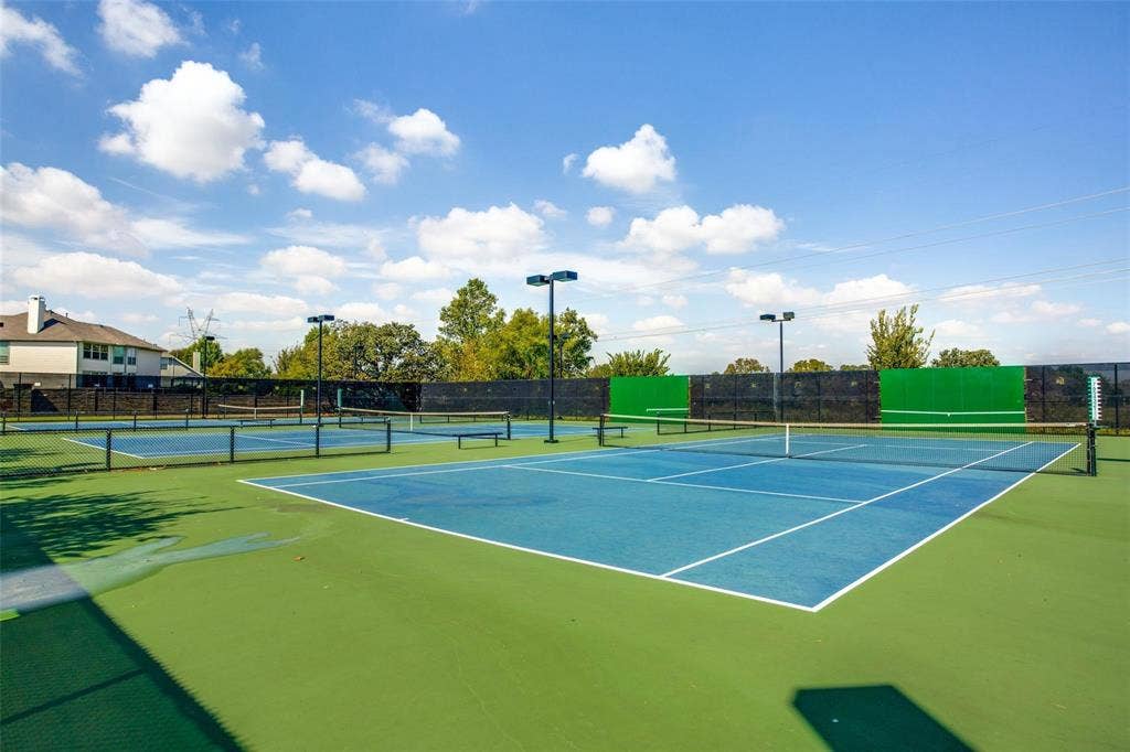 Tennis courts with blue playing surfaces and green surrounds