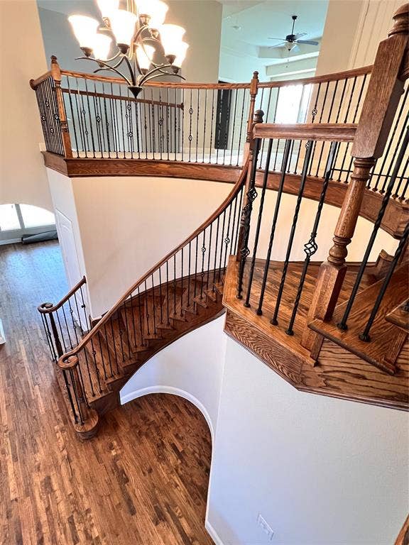Grand two-story foyer featuring a curved staircase with wood-finish treads, wrought iron balusters, and a matching wood-finish handrail