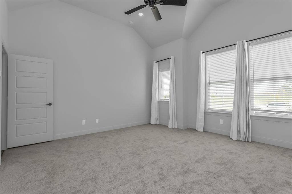 1031 Rylan Street, Midlothian, TX 76065 Spacious room with a vaulted ceiling, light gray carpeting, and multiple windows featuring blinds and drapes