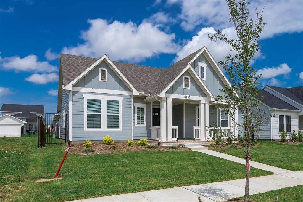 1031 Rylan Street, Midlothian, TX 76065 Cottage-style home featuring a light blue siding, white trim, and a covered front porch with white columns
