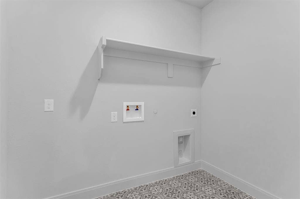 1031 Rylan Street, Midlothian, TX 76065 Laundry area with patterned floor tile, overhead shelving, and essential appliance hookups