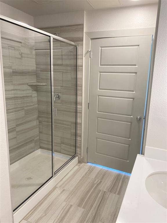 1514 E 15th Street, #10, Plano, TX 75074 Modern bathroom featuring a glass-enclosed shower with horizontal tile surround and a built-in shower shelf