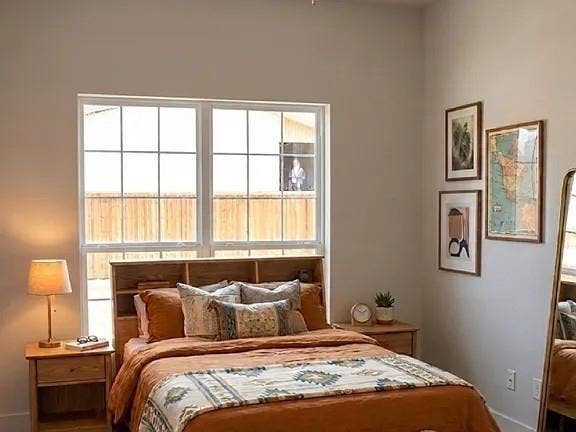 1514 E 15th Street, #10, Plano, TX 75074 Spacious bedroom featuring large grid-pattern windows, light wood-finish built-in headboard, light wood-finish side tables, and soft neutral wall tones