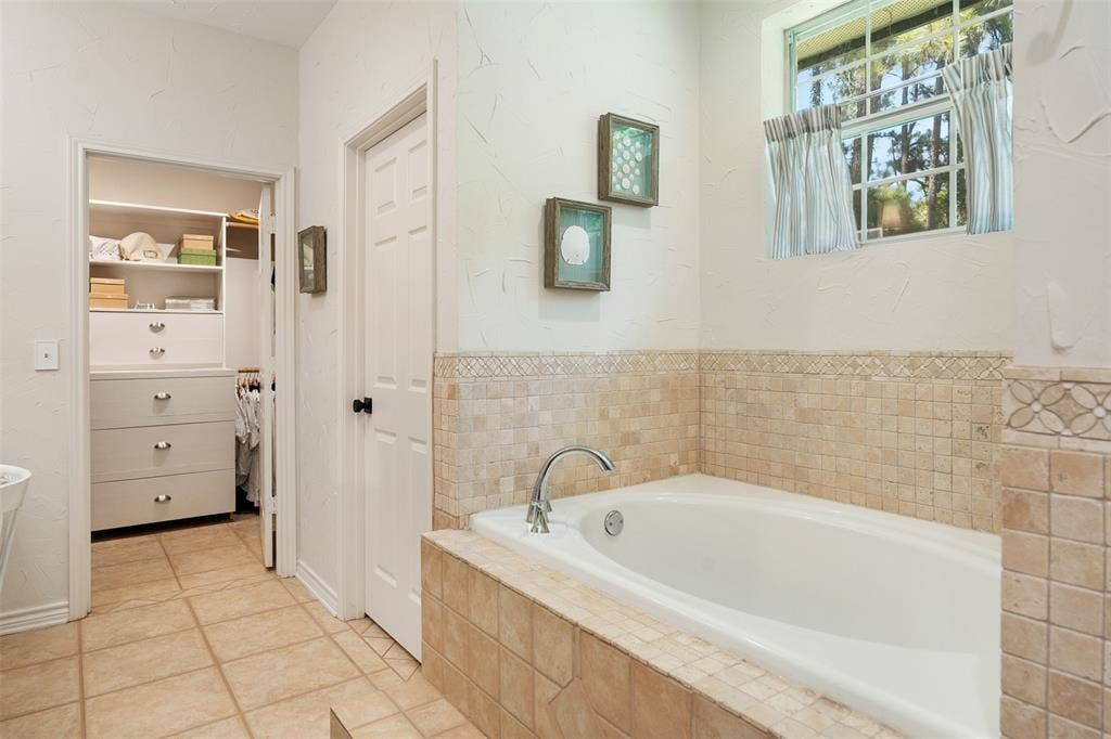 primary bath with separate tub and large walk in closet