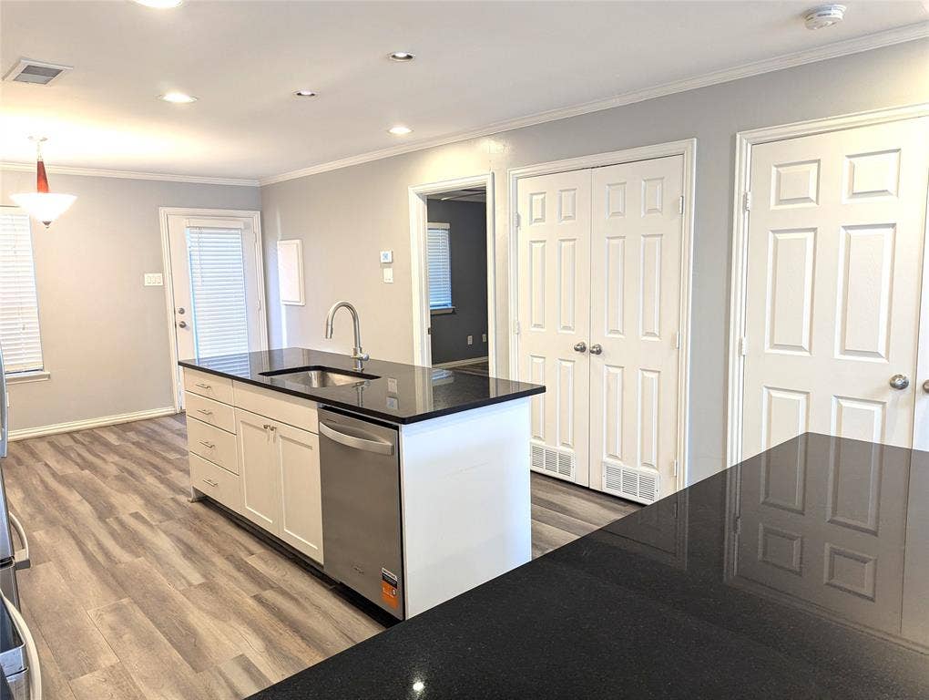 509 Pine Trail Drive, Allen, TX 75002 Kitchen island with dark countertops, wood-finish flooring, white cabinetry, stainless steel sink, and recessed lighting