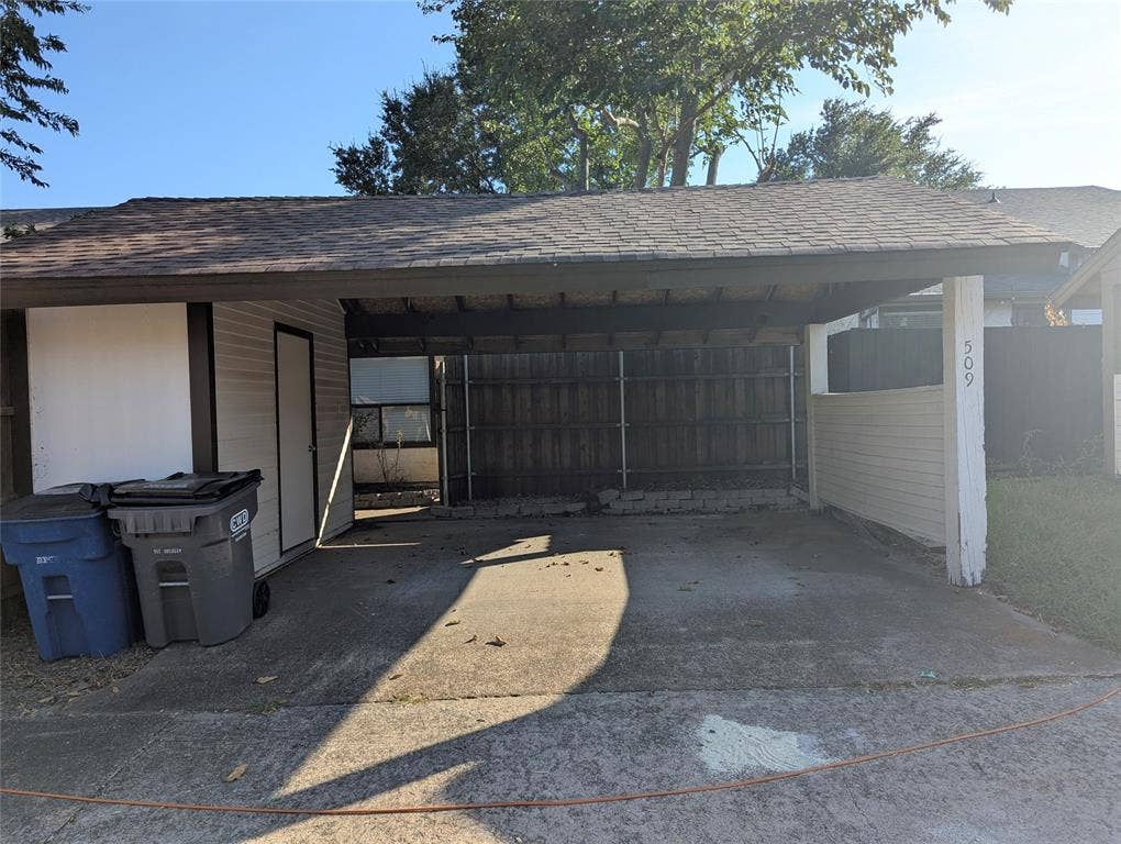 509 Pine Trail Drive, Allen, TX 75002 Paved carport with an attached storage shed, horizontal paneling, and a wood privacy fence