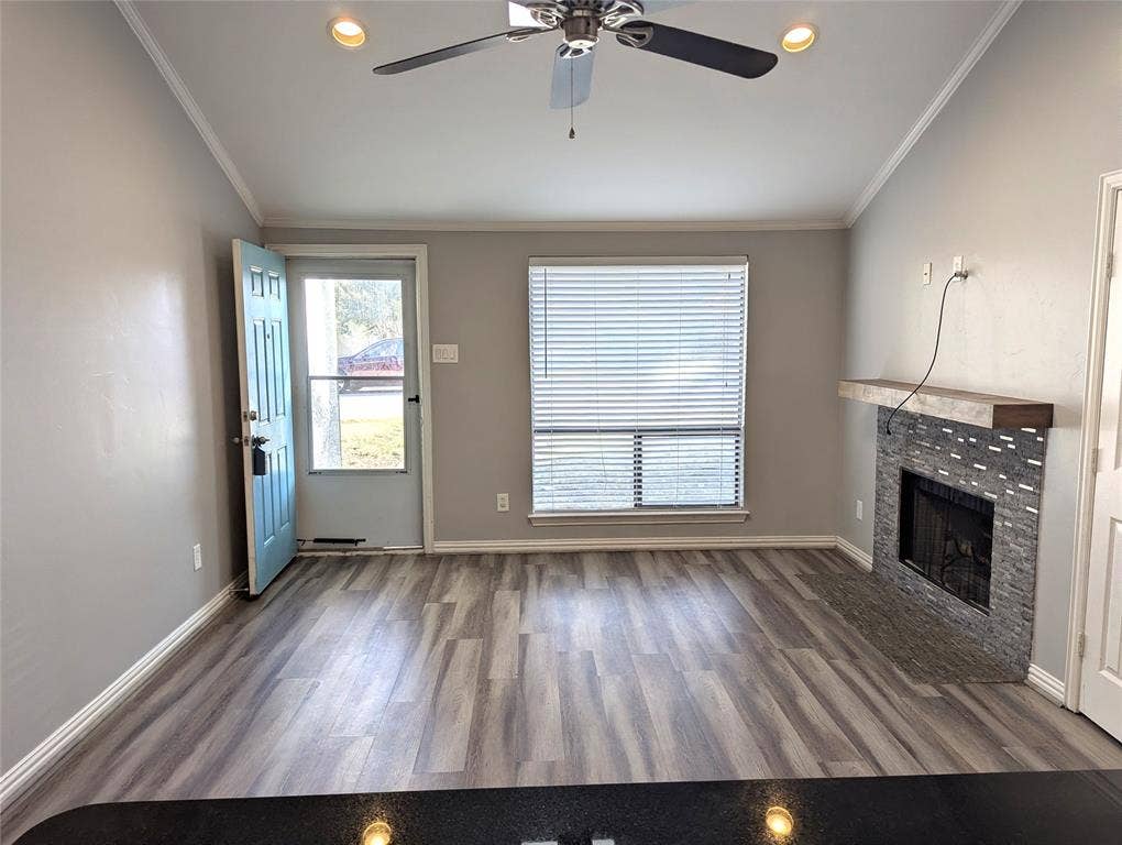 509 Pine Trail Drive, Allen, TX 75002 Open concept living area featuring wood-finish flooring, a fireplace with a stone surround and wood mantel, vaulted ceilings, and recessed lighting