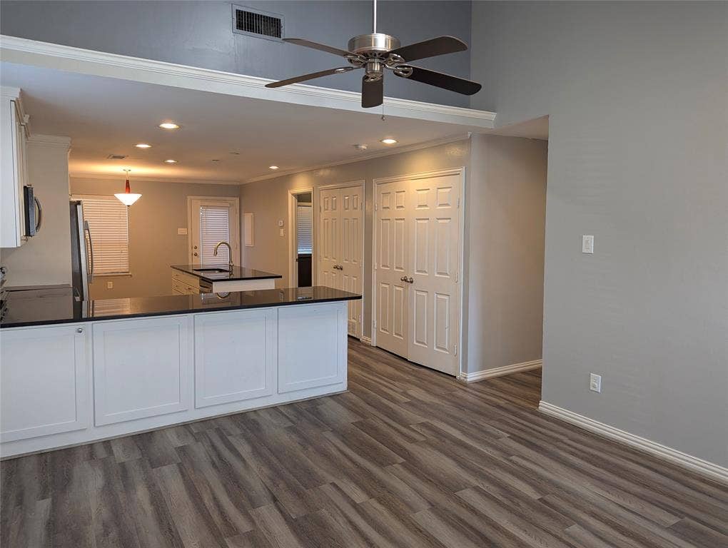 509 Pine Trail Drive, Allen, TX 75002 Open-concept kitchen with dark countertops, white cabinetry, a kitchen island with a sink, and wood-finish flooring