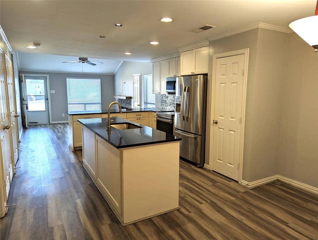 509 Pine Trail Drive, Allen, TX 75002 Kitchen featuring dual islands with dark countertops, white cabinetry, stainless steel appliances, and wood-finish flooring