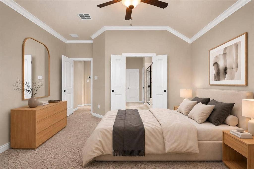 Carpeted room featuring a vaulted ceiling with crown molding, a ceiling fan with integrated lighting, and multiple paneled doors with dark hardware